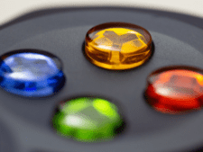 Nahaufnahme eines Spielkonsolen-Controlers, zu sehen ist das Spielkreuz mit den Buchstabenknöpfen, der gelbe "Y-"Knopf ist fokussiert, alle anderen verschwommen