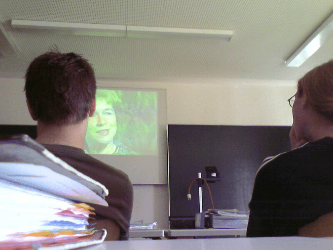 Rückenansicht zweier Menschen, die sich einen Film anschauen, Schul- oder Unisetting