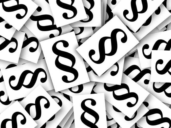 Viele übereinanderliegende weiße Blätter mit dem Paragraphen-Zeichen