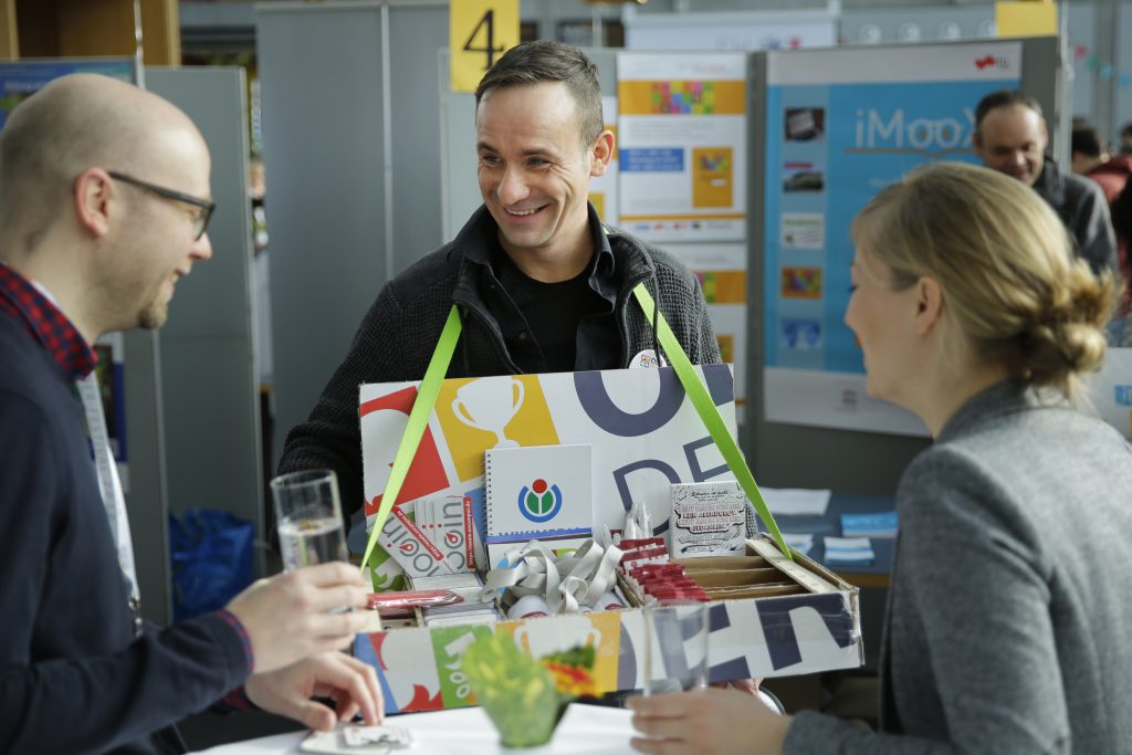 Der Mann mit dem Bauchladen verteilt Give-Aways der Veranstaltungspartner, z.B. Wikimedia Deutschland und bpb