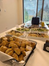 Brötchenkorb im Vordergrund, dahinter mehrere Salate, Einmachgläser und Suppenpots